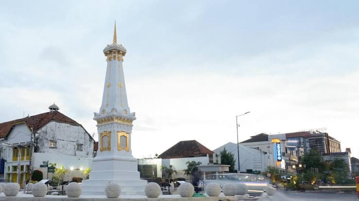 The white and gold Tugu monument at the Yogyakarta crossroads at dusk