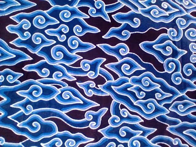 Hand-drawn batik cloth in indigo and white, patterned with the curling megamendung cloud motif