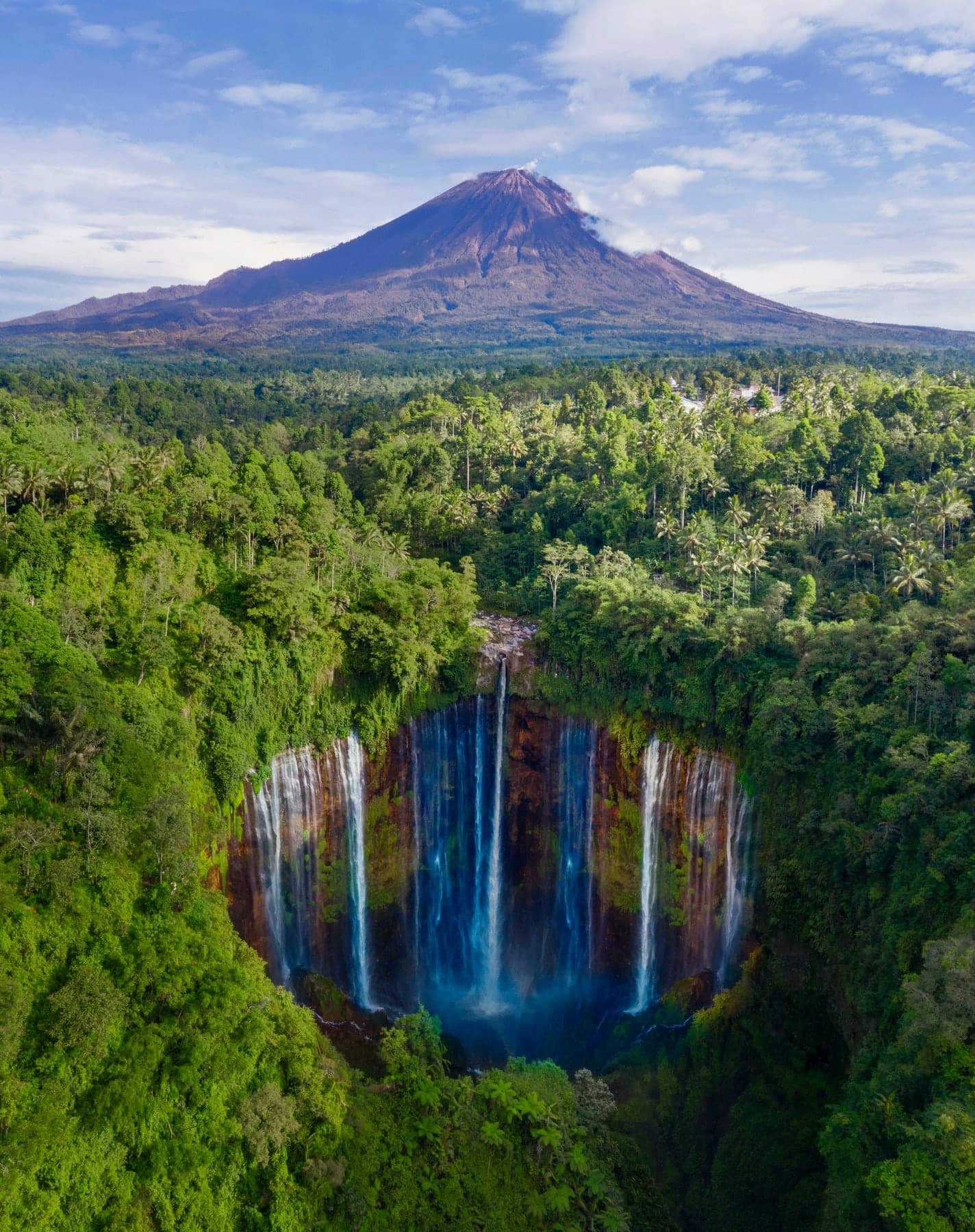 Tumpak Sewu waterfall and Mount Semeru seen from above, the full drop of the falls visible